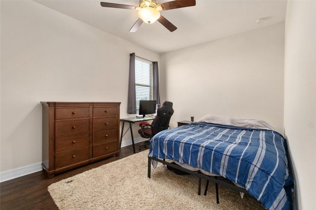Bedroom featuring dark wood-style flooring, baseboards, and ceiling fan | Image 24