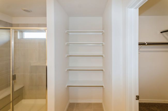 Full bathroom featuring a shower stall, a spacious closet, and baseboards | Image 13