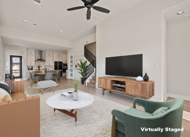 Living room with ceiling fan, light wood-type flooring, baseboards, and stairs | Image 8