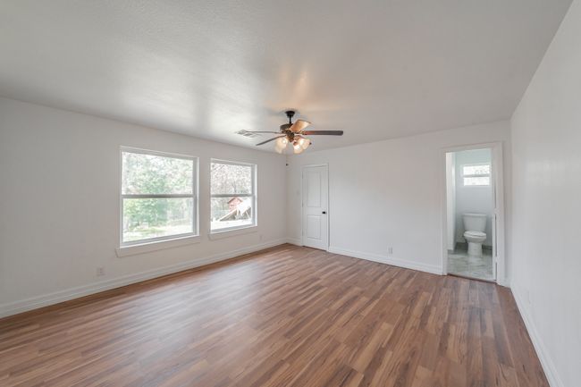 Spare room with wood finished floors, baseboards, and ceiling fan | Image 16