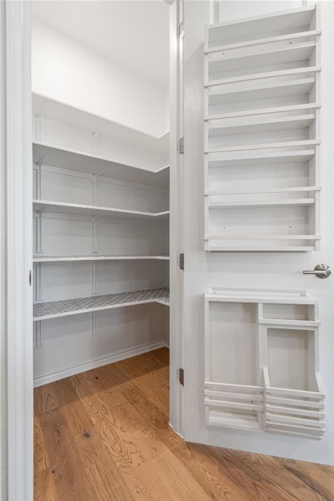 Walk-in pantry with extra shelving/storage on the door. | Image 10
