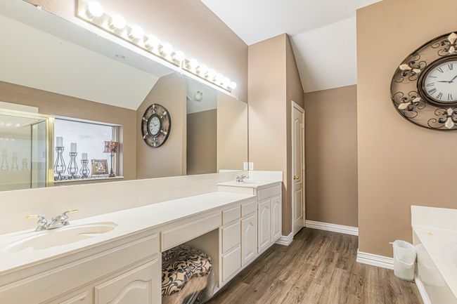 Full bathroom with double vanity, a bath, wood finished floors, and vaulted ceiling | Image 24