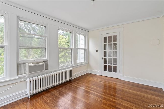 Bedroom with radiator, wood finished floors, and baseboards | Image 33