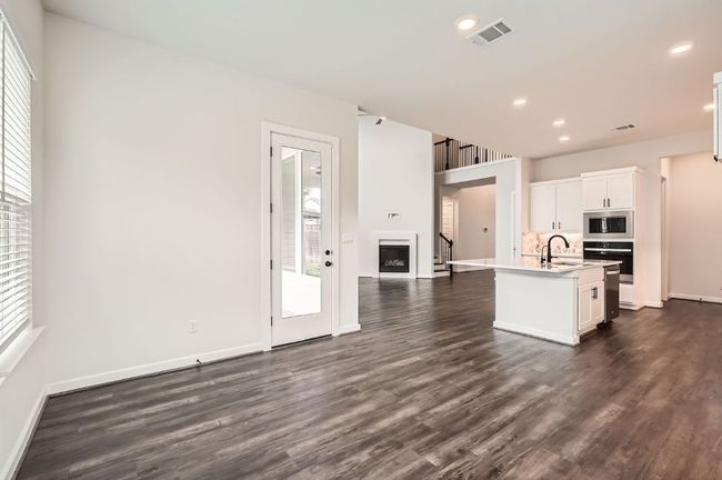 Kitchen featuring wall oven, dark wood-style flooring, stainless steel microwave, light countertops, and recessed lighting | Image 7
