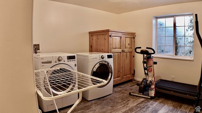 Washroom with cabinet space, washing machine and clothes dryer, wood finished floors, and baseboards | Image 53