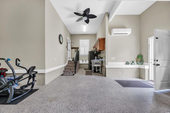 Foyer entrance with a wall mounted AC, a ceiling fan, and speckled floor | Image 25