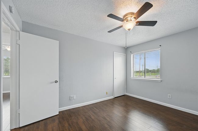 Unfurnished room with a textured ceiling, ceiling fan, and wood finished floors | Image 12