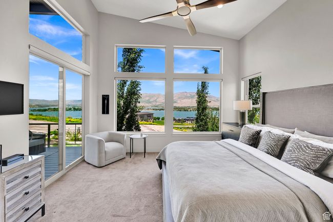 Carpeted bedroom featuring access to exterior, high vaulted ceiling, a water and mountain view, and ceiling fan | Image 29