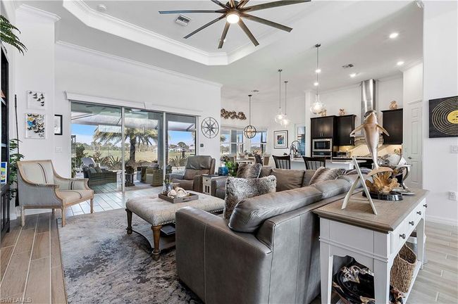 Living area with a wealth of natural light, visible vents, ceiling fan, and wood tiled floor | Image 33