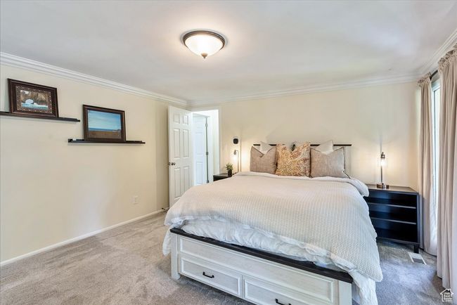 Bedroom featuring light colored carpet and ornamental molding | Image 35