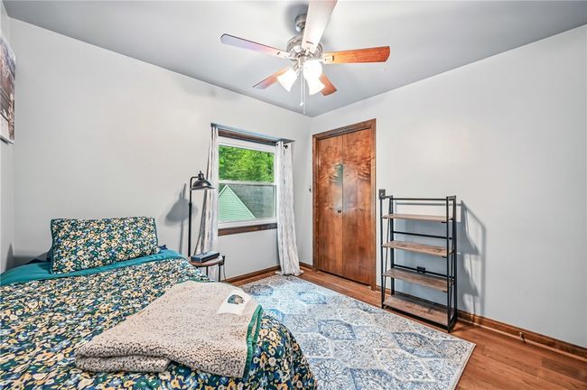 Cozy bedroom with hardwood floors, a ceiling fan, and a comfortable feel. | Image 33