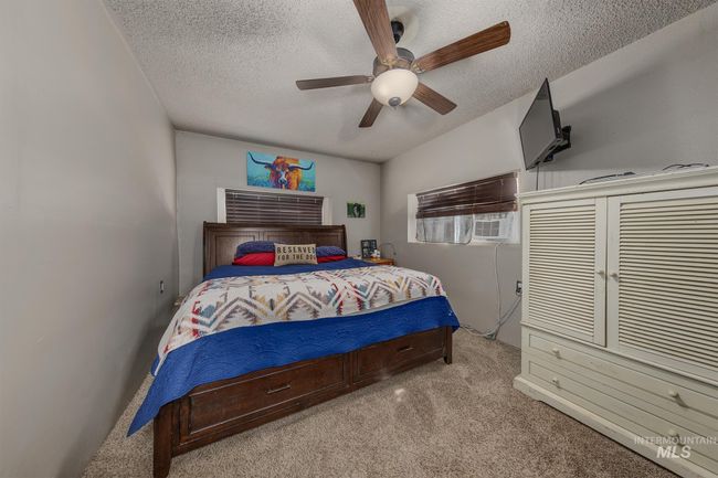 Bedroom with light carpet, a textured ceiling, and ceiling fan | Image 13