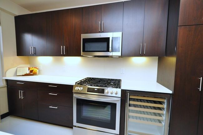 Fully renovated Eat-in-Kitchen has custom mocha colored cabinets, Quarts counters and stainless steel appliances including a wine cooler, dishwasher, microwave, range and refrigerator. | Image 11