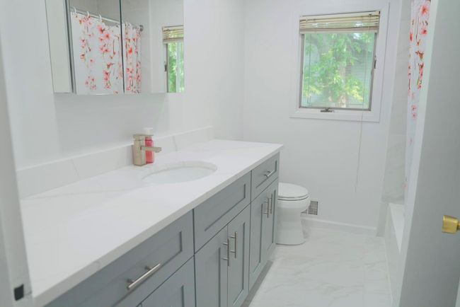 Full bath with vanity and marble look tiles | Image 13