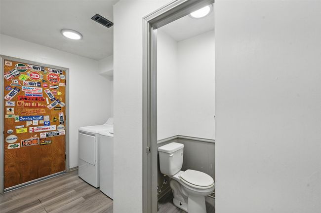 Laundry room with light wood-type flooring and washing machine and clothes dryer | Image 12