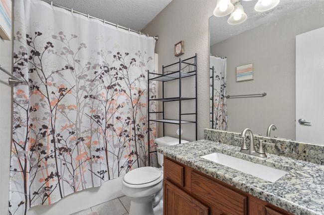 Full bathroom with vanity, toilet, a textured ceiling, and tile patterned flooring | Image 24