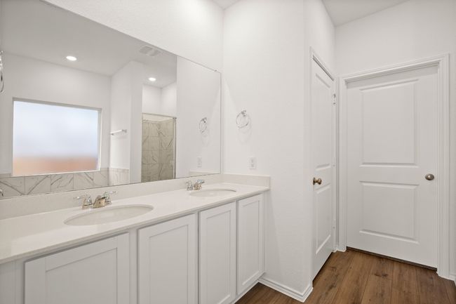 Full bathroom featuring double vanity, wood finished floors, a sink, and visible vents | Image 14