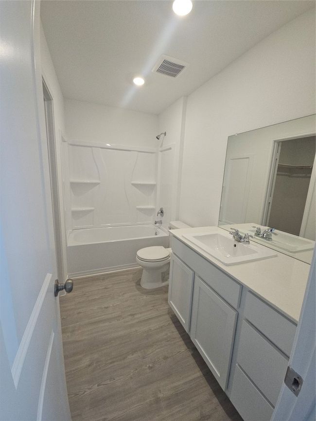 Bathroom with vanity, toilet, wood finished floors, bathing tub / shower combination, and recessed lighting | Image 21