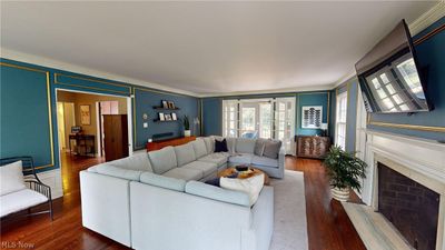 Living room with crown molding, hardwood floors, and french doors to sun room | Image 3