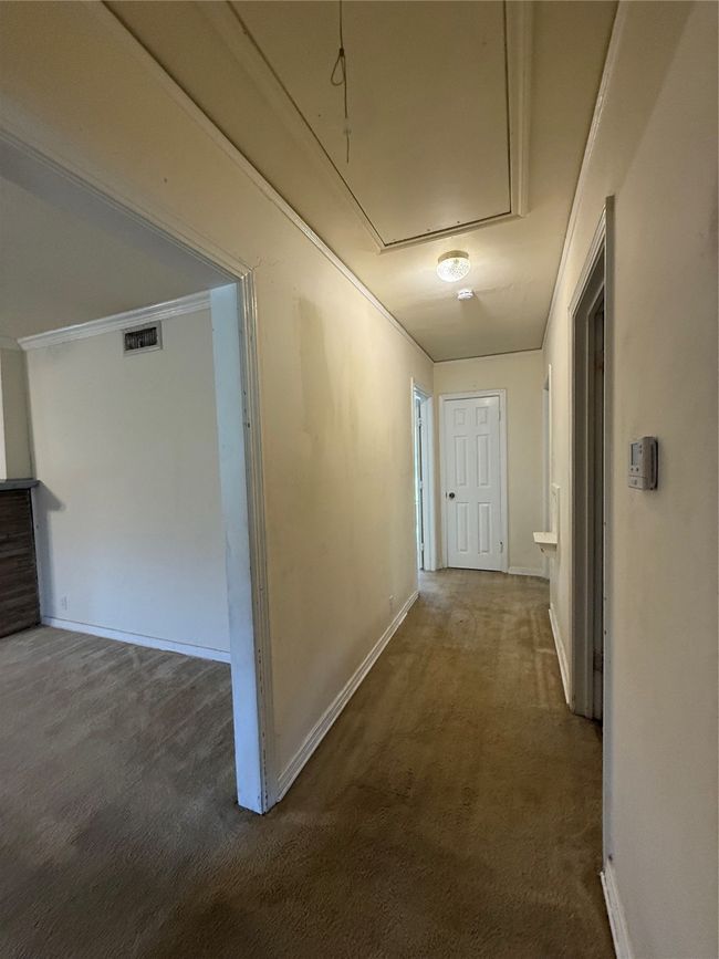 Hallway with attic access and carpet floors leading to 3 bedrooms | Image 8