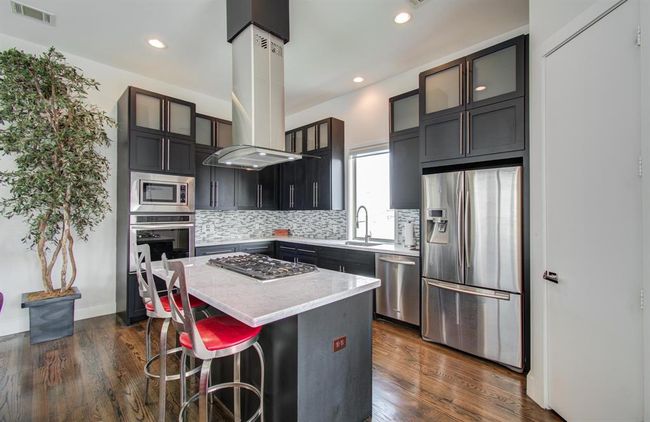 Large island with extra seating, gas cooktop, and so much space to gather here in the kitchen. | Image 14