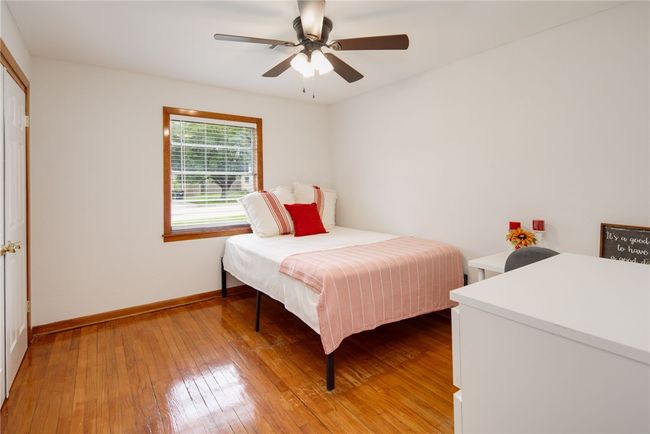 Bedroom with light wood-type flooring, baseboards, and ceiling fan | Image 18