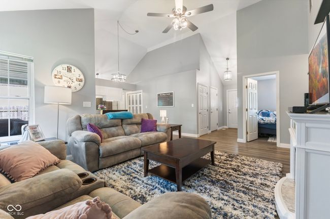 living room featuring ceiling fan, wood finished floors, and high vaulted ceiling | Image 5