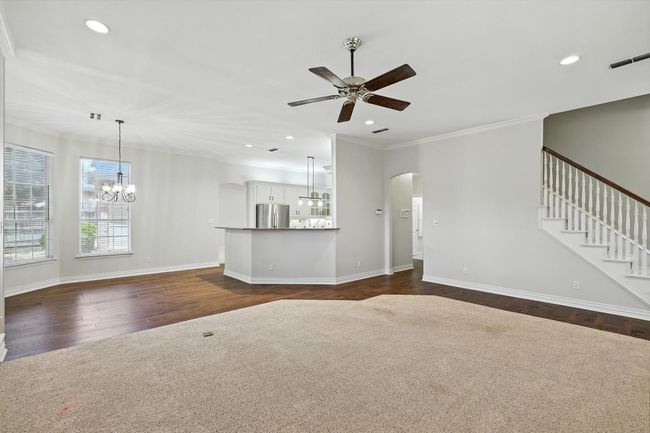 Family Room with a chandelier, a ceiling fan, dark wood-style flooring, recessed lighting, and arched walkways | Image 11