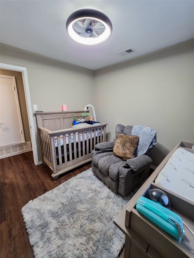 Bedroom with wood finished floors and a textured ceiling | Image 9