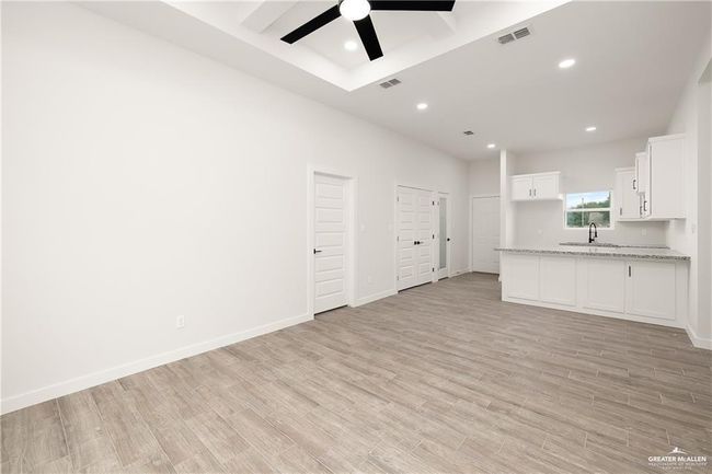 Unfurnished living room with a ceiling fan, light wood-style flooring, and recessed lighting | Image 4