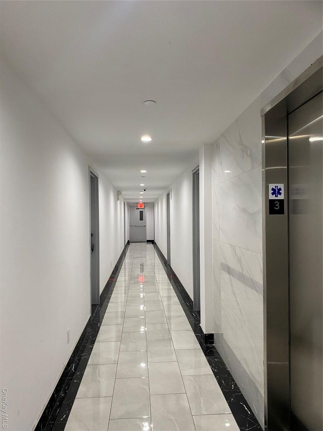 Hall featuring elevator, light marble finish flooring, inlaid floor details, and recessed lighting | Image 4