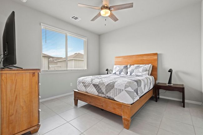 Bedroom with baseboards, light tile patterned floors, and ceiling fan | Image 8