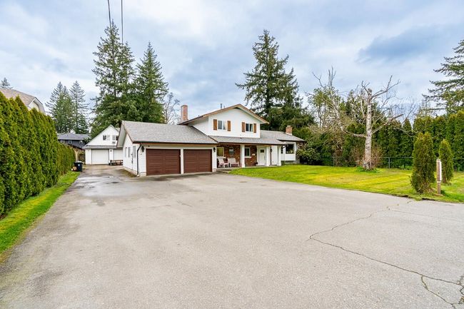 View of front of property with a chimney, a garage, fence, and a front yard | Image 6