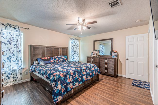 Master bedroom with wood finished floors | Image 13