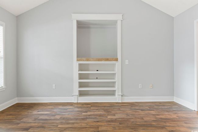 Unfurnished bedroom with lofted ceiling, dark wood finished floors, multiple windows, and baseboards | Image 7