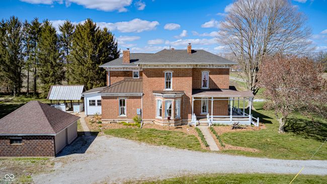 view of front facade with a porch, brick siding, a chimney, and a front lawn | Image 75