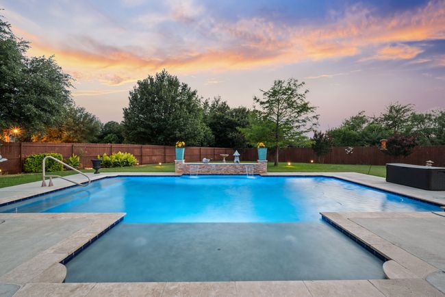 View of swimming pool featuring a fenced backyard and a patio area | Image 6