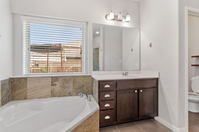 Full bathroom with tile patterned floors, toilet, vanity, and a garden tub | Image 25