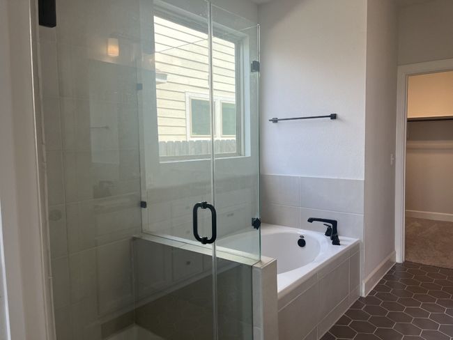 Full bath featuring a bath, tile patterned flooring, a stall shower, baseboards, and a spacious closet | Image 18
