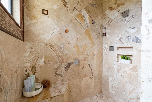The second primary en-suite bath features a luxuriuos spa tub and beautifully tiled shower equiped with a sun shower and multiple body jets for a relaxing retreat. | Image 45