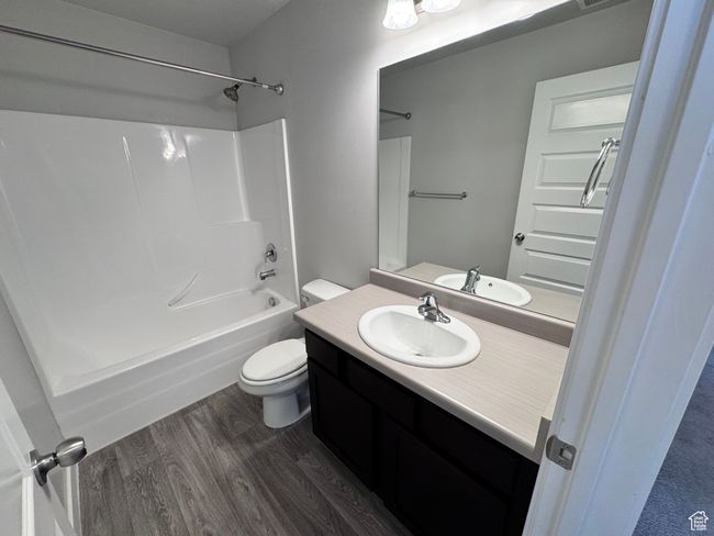 Bathroom featuring shower / tub combination, wood finished floors, toilet, and vanity | Image 21