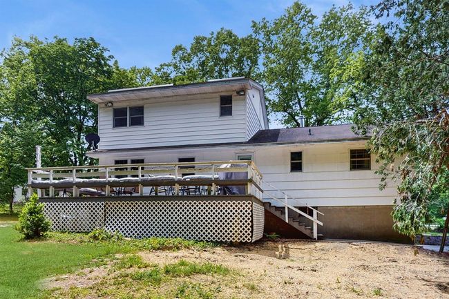 Back of property with a wooden deck and stairs.The brown areas in this picture are new grass seeded areas as a result of the installing the brand new Septic System! | Image 39