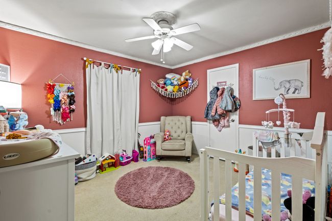 Bedroom featuring a wainscoted wall, carpet, crown molding, and ceiling fan | Image 13