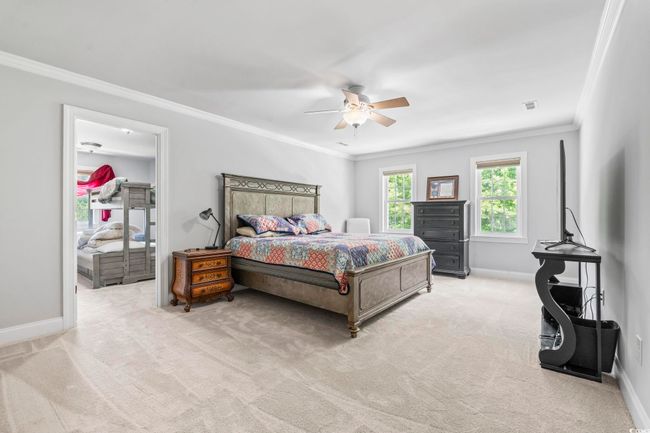Carpeted bedroom featuring crown molding, baseboards, and a ceiling fan | Image 21