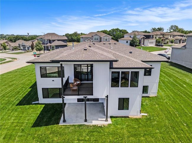 Back of house featuring roof with shingles, a residential view, a yard, and a patio area | Image 36