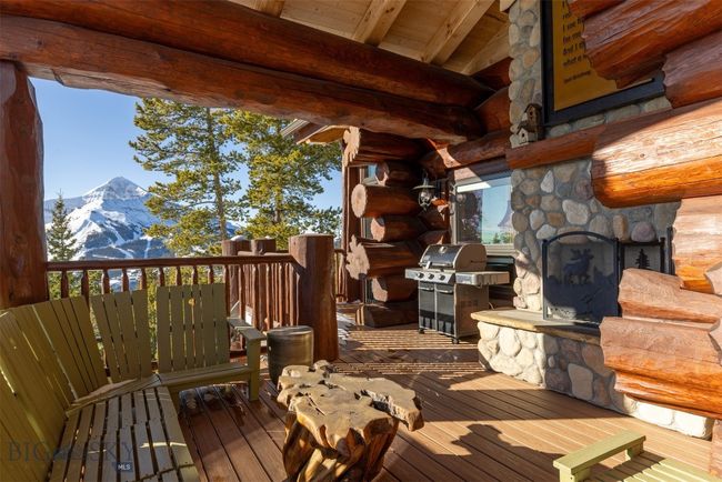 Covered deck area with exterior fireplace, propane grill and plenty of seating to enjoy those mountain views. | Image 65