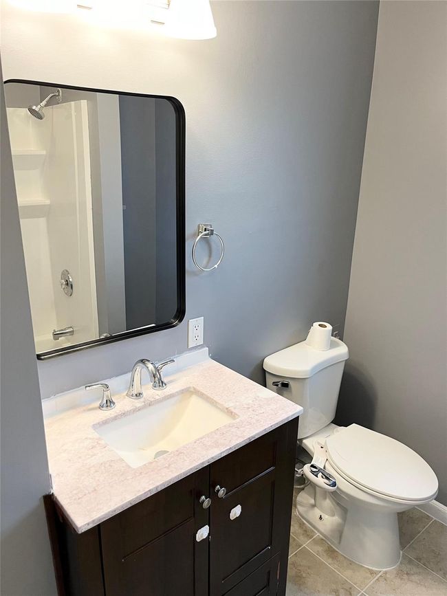 Bathroom with vanity, tile patterned flooring, toilet, and a shower | Image 18