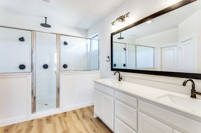 Bathroom with hardwood / wood-style floors, an enclosed shower, and dual vanity | Image 11