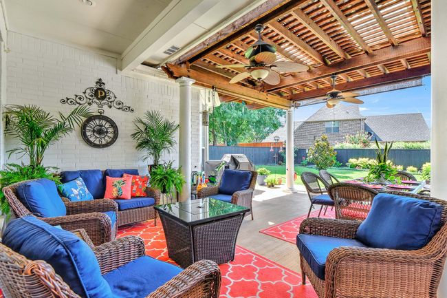 Fenced backyard with outdoor lounge area, ceiling fan, and a patio | Image 32