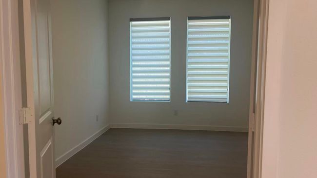 Spare room featuring baseboards and dark wood-type flooring | Image 10
